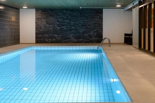 a large swimming pool with blue tiles on the floor at Scandic Borlänge in Borlänge