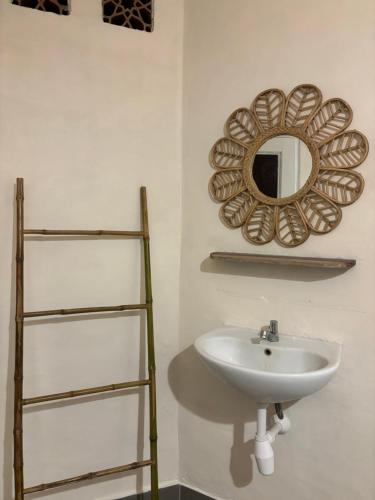 a bathroom with a sink and a mirror on the wall at Little Pearl in Gili Trawangan