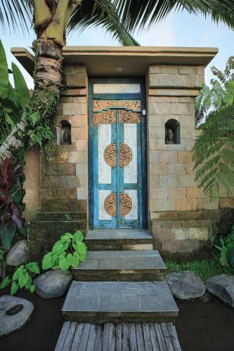 a house with a blue door and some stairs at Lawani Resort in Tegalalang