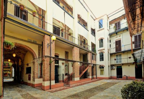 a courtyard of an old building with an archway at Palazzo Centro Alloggi Vacanza in Nizza Monferrato
