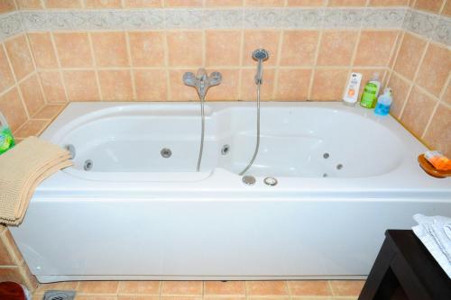 a white bath tub in a tiled bathroom at Aesthetic Delight - Stone Villa in Mystras in Mystras