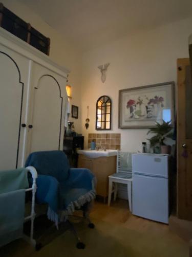a living room with a blue chair and a sink at King Comfort tv microwave fridge in Upton