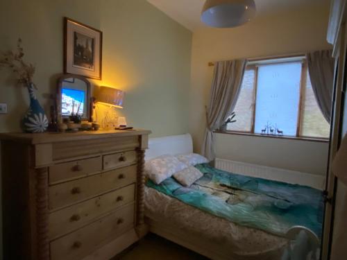a bedroom with a bed and a dresser and a mirror at King Comfort tv microwave fridge in Upton
