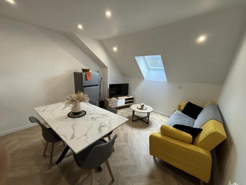a living room with a yellow couch and a table at Le Voyageur - 4 p - Circuit Rêve au Mans in Écommoy
