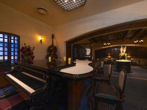 a living room with a piano and chairs at Kumamoto Hotel Castle in Kumamoto