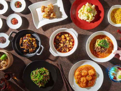 a table with plates of food and bowls of food at Kumamoto Hotel Castle in Kumamoto