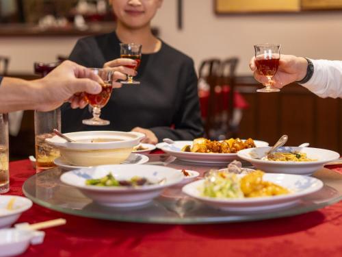 a group of people sitting around a table with plates of food at Kumamoto Hotel Castle in Kumamoto