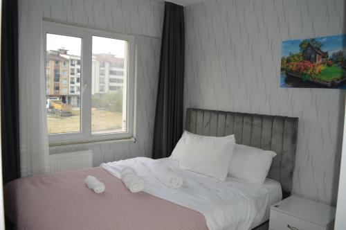 a bedroom with a bed with white sheets and a window at Classic Suite AA7 in Esenyurt