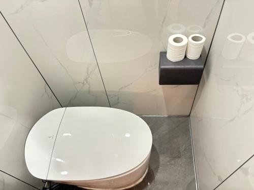 a white toilet in a bathroom with two rolls of toilet paper at Banyueli Hotel in Shanghai