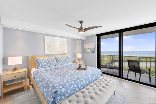 a bedroom with a bed and a view of the ocean at Elegant beachfront condo in private community in Marco Island