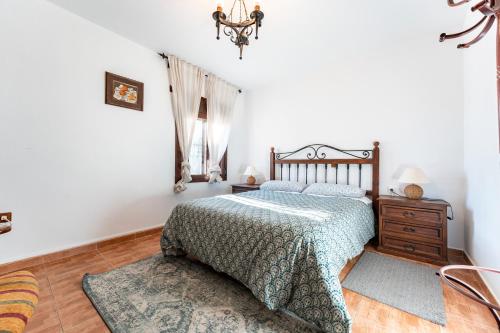 a bedroom with a bed and a dresser and a chandelier at Palm House in Fuengirola
