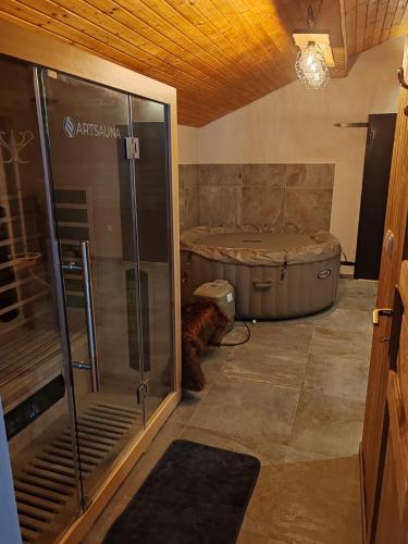 a bathroom with a tub and a dog laying next to it at House Sara in Latin