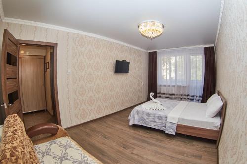 a hotel room with a bed and a television at АЛЬ-ТАИР Апартаменты 1-ком в центре in Petropavlovsk