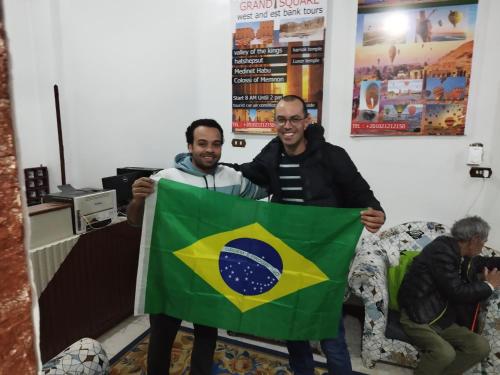 two men are holding a brazilian flag at Grand Square Hostel Luxor in Luxor