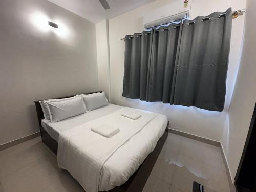 a small room with a bed with a black curtain at Trinetra Homes 102 in Bengaluru