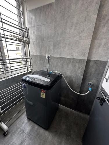 a bathroom with a bath tub with a water hose at Trinetra Homes 102 in Bangalore