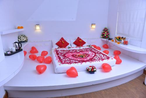 a white table with a cake with hearts on it at Westwood Riverside in Munnar
