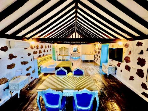 a room with a bed and blue chairs in it at Hacienda de Las Indias, La Habana in Granadilla de Abona