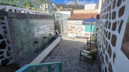 a patio with two chairs and an umbrella at Hacienda de Las Indias, La Habana in Granadilla de Abona