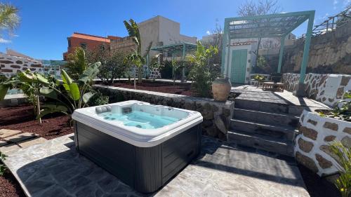 a hot tub in a garden with a building at Hacienda de Las Indias, La Habana in Granadilla de Abona