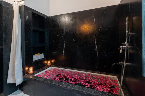 a bathroom with a tub filled with red flowers at Panna Vilas - A Lake Facing Boutique Hotel in Udaipur