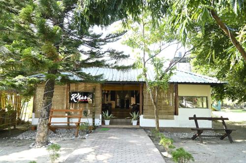 a building with two benches in front of it at Jironi Resort in Tezpur