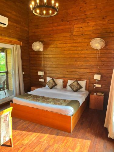 a bedroom with a bed in a wooden room at Jironi Resort in Tezpur