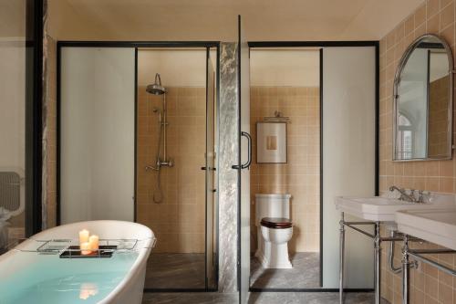 a bathroom with a tub and a shower and a sink at 归相Golden Age酒店 in Chengdu