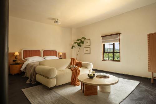a bedroom with a bed and a couch and a table at 归相Golden Age酒店 in Chengdu