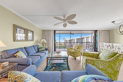 a living room with blue couches and a ceiling fan at Sundial P401 in Sanibel