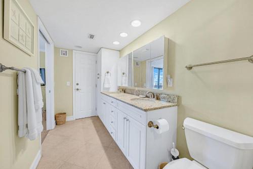 a bathroom with a sink and a toilet and a mirror at Sundial P401 in Sanibel