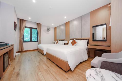 a hotel room with two beds and a flat screen tv at Lam Anh Hotel 8 Ngoại Giao Đoàn BT3-10 in Hanoi