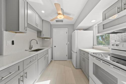 a kitchen with white cabinets and a ceiling fan at Rabbit Retreat in Sanibel