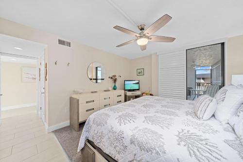 萨尼贝尔Compass Point #243的一间卧室，里面有一张床和一个吊扇