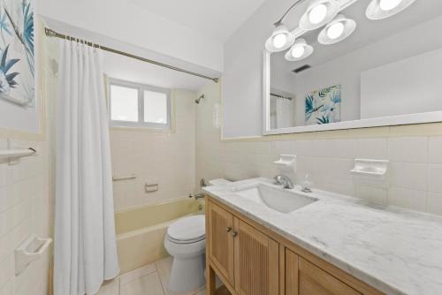 a bathroom with a sink and a toilet and a mirror at Rabbit Retreat in Sanibel