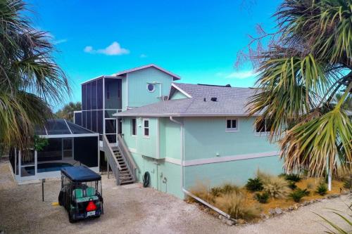 a house with a golf cart parked in front of it at Rabbit Retreat in Sanibel