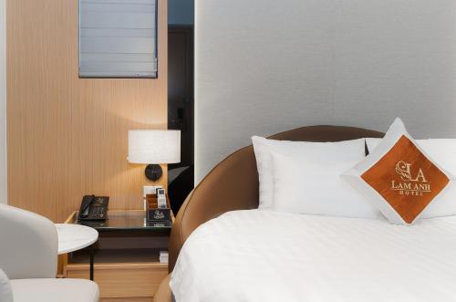 a hotel room with a bed and a table with a phone at Lam Anh Hotel 8 Ngoại Giao Đoàn BT3-10 in Hanoi