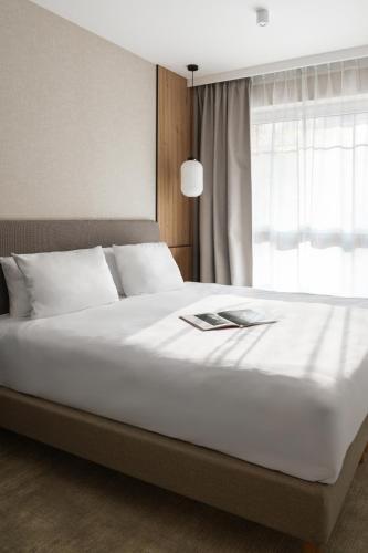 a bedroom with a large white bed with a window at Mövenpick Resort & Spa Karpacz in Karpacz