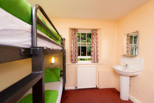 ein Schlafzimmer mit einem Etagenbett und einem Waschbecken in der Unterkunft YHA Grasmere Butharlyp Howe in Grasmere