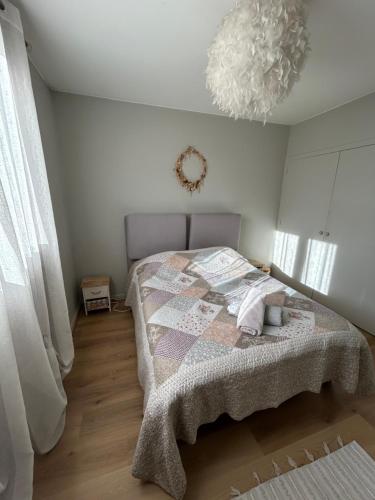 une chambre avec un lit et un lustre dans l'établissement T3 résidence BEL AIR - Limoges - CHU - parking, à Limoges