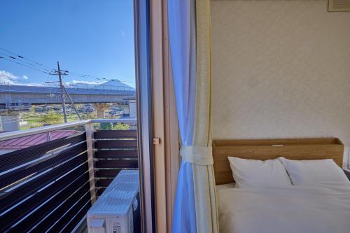 a bedroom with a bed and a balcony with a window at APRO STAY FujiKawaguchiko-Kotobuki13 in Fujiyoshida