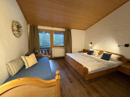 a bedroom with a large bed and a large window at Dreimäderlhaus am Berg in Pfronten