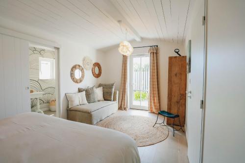 une chambre avec un lit, un canapé et une fenêtre dans l'établissement Villa Dune, au Bois-Plage-en-Ré