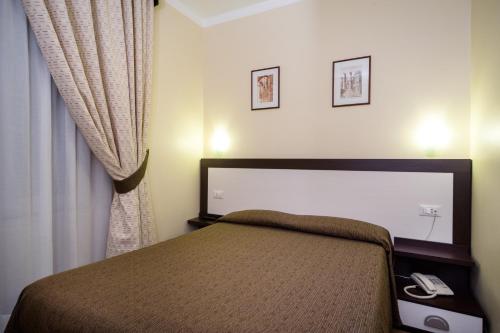 a bedroom with a bed and a phone in it at Hotel Boccascena in Genova