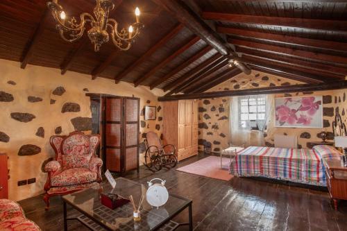 a living room with a chandelier and a couch and a bed at Ancana in Vega de San Mateo