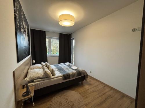 Ένα ή περισσότερα κρεβάτια σε δωμάτιο στο Mazurski Sad apartament Juno