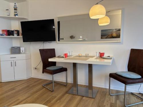 a room with a table and two chairs and a tv at Apartment Ostseeblick 131 in Timmendorfer Strand