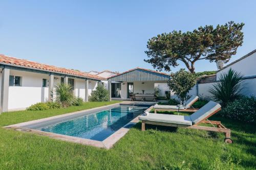 une piscine dans l'arrière-cour d'une maison dans l'établissement Villa Blue, au Bois-Plage-en-Ré