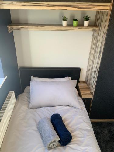 a bed with two towels and two plants on it at The Nest - Cosy Rooms in Harwood
