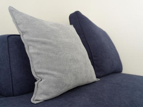 a pillow sitting on top of a blue couch at OUCHI HOTEL Onaganishi in Hiroshima